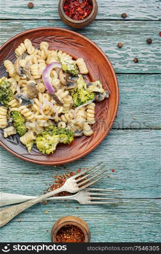 Plate of iItalian pasta with broccoli.Italian food.Vegetarian vegetable pasta wooden table.. Broccoli pasta in plate