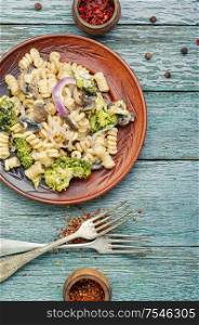 Plate of iItalian pasta with broccoli.Italian food.Vegetarian vegetable pasta wooden table.. Broccoli pasta in plate
