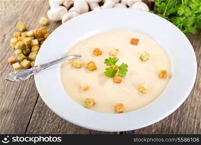 plate of mushroom soup on wooden background