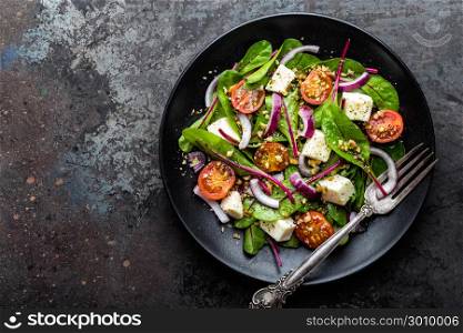 plate of nutritious simple salad with chard, walnuts, soft cheese, onions and oil, top view, space for text