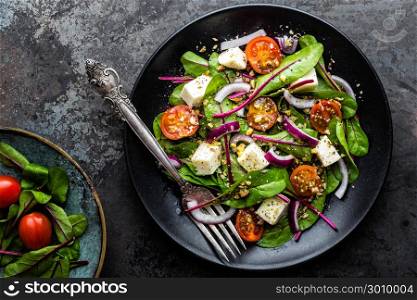plate of nutritious simple salad with chard, walnuts, soft cheese, onions and oil
