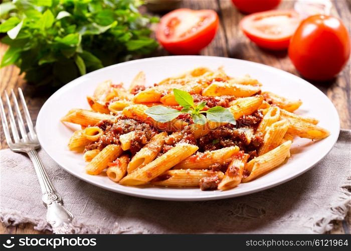 plate of pasta bolognese on wooden table