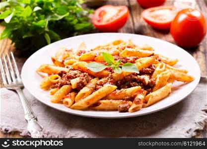 plate of pasta bolognese on wooden table