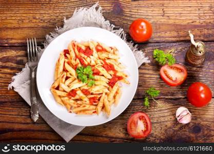 plate of pasta with tomato sauce on wooden table