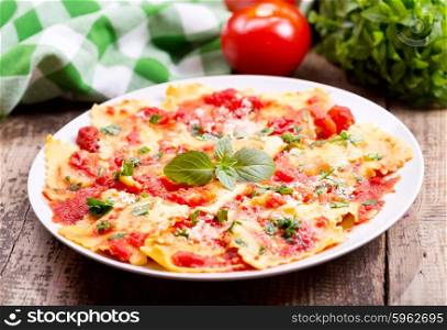 plate of ravioli with tomato sauce on wooden table