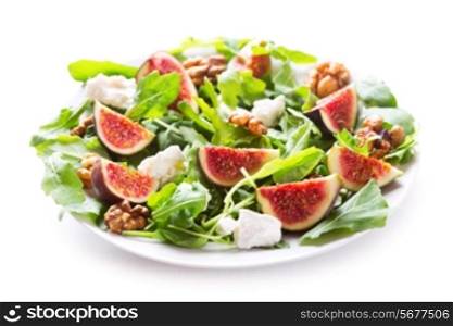 plate of salad with figs, arugula, walnut and feta cheese on white background