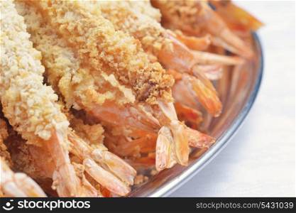 plate of sauteed prawns in breadcrumbs with sauce