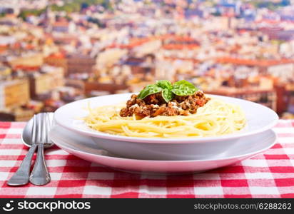 plate of spaghetti bolognese over cityscape