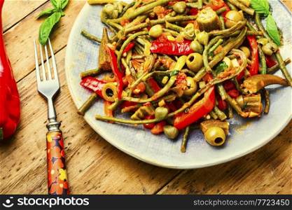 Plate of stewed vegetables with hot spices. Pepper, tomato and asparagus appetizer. Mexican food.. Appetizer of stewed vegetables with spices