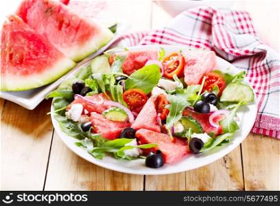 plate of watermelon salad on wooden table