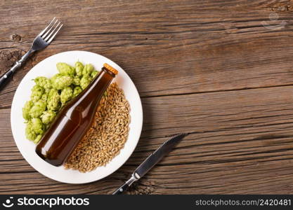 plate with beer ingredients wooden background