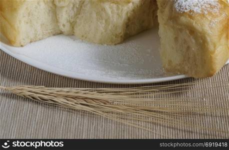 Plate with cake and wheat ears. Still life of homemade baking wheat spikes on a table. Vintage
