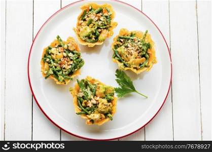 Plate with cheese basket with avocado,cowpea and nuts.Banquet,holiday food. Cheese basket stuffed with vegetables
