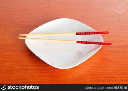 Plate with chopsticks on the wooden table