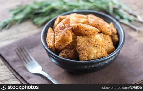 Plate with fried ravioli on the wooden board