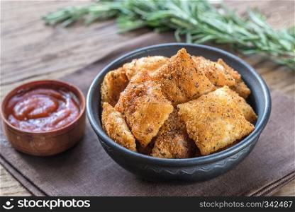 Plate with fried ravioli on the wooden board