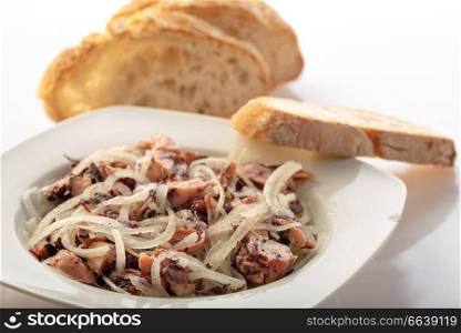 plate with octopuss salad with bread behind tipical portuguese delicacy dish