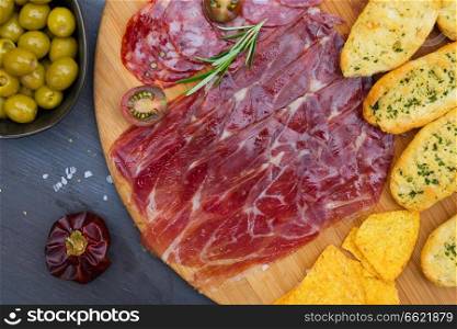 Plate with spanish jamon and chorizo tapas, picnic table. Table with spanish tapas