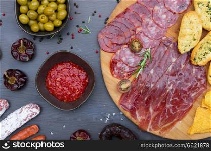 Plate with spanish jamon ham and chorizo tapas, picnic table top view. Table with spanish tapas