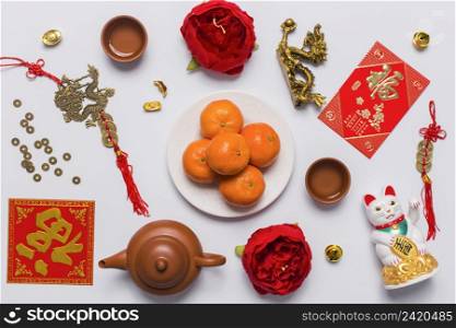 plate with tangerines amidst chinese stuff
