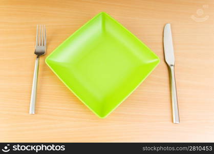 Plate with utensils on wooden table