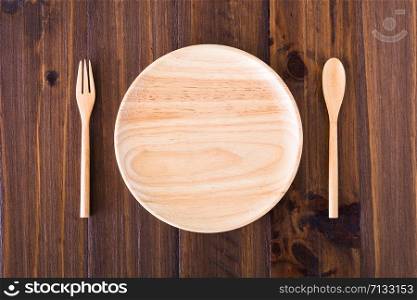 Plates, utensils made of wood put on a wooden floor.