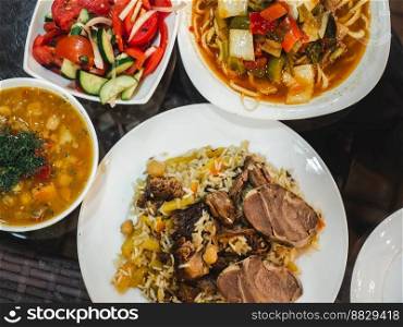 Plates with fragrant pilaf are on the table. Close-up, indoors, directly above . Tasty and healthy food concept. Plates with fragrant pilaf are on the table