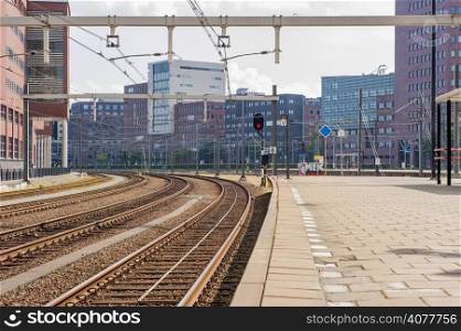 Platform with railway tracks in urban scenery of office buildings