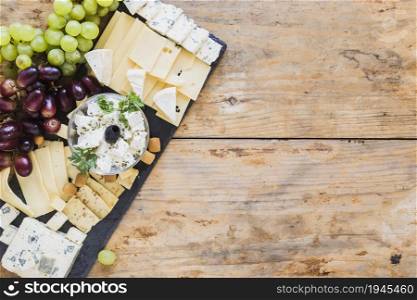 platter cheese with grapes black slate board table. High resolution photo. platter cheese with grapes black slate board table. High quality photo