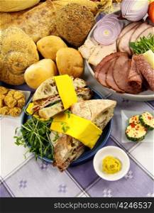 Platter full of fresh ingredients to make sandwiches along with selection of breads.