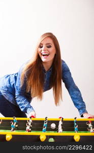 Play and fun concept. Young focused girl having fun with table soccer game. Fashionable woman playing spending free time on recreation.. woman playing table football game