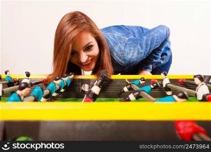 Play and fun concept. Young focused girl having fun with table soccer game. Fashionable woman playing spending free time on recreation.. woman playing table football game
