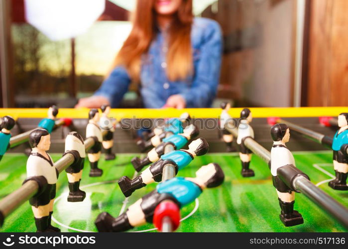 Play and fun concept. Young focused girl having fun with table soccer game. Fashionable woman playing spending free time on recreation.. woman playing table football game
