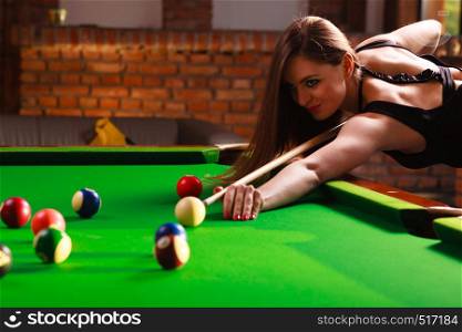 Play and fun concept. Young happy girl having fun with billiard. Smiling fashionable woman playing spending time on recreation.. Young woman having fun with billiard.
