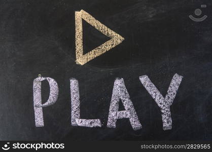 play sign drawn with chalk on blackboard