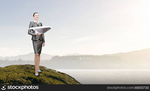 Playful approach to paper work. Attractive businesswoman holding paper plane in hands