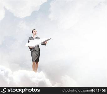Playful approach to paper work. Attractive businesswoman holding paper plane in hands