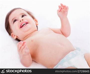 Playful baby lying with has hands up in a white isolated background
