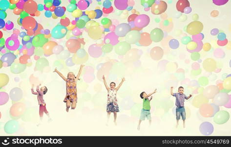 Playful children catch balloons. Group of happy children playing with colorful balloons