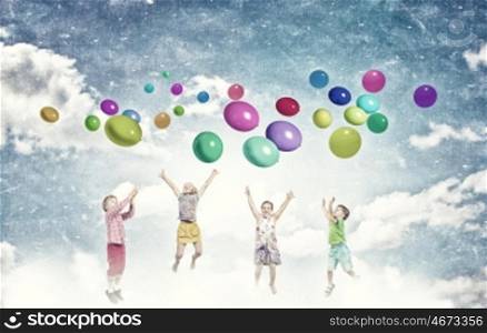 Playful children catch balloons. Group of happy children playing with colorful balloons
