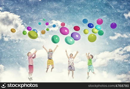 Playful children catch balloons. Group of happy children playing with colorful balloons