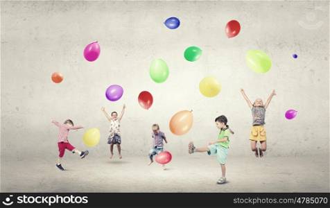 Playful children catch balloons. Group of happy children playing with colorful balloons