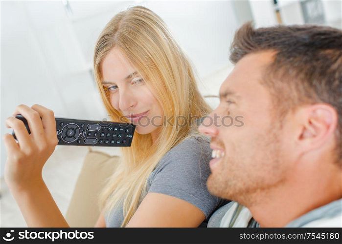 Playful couple fighting over the TV remote