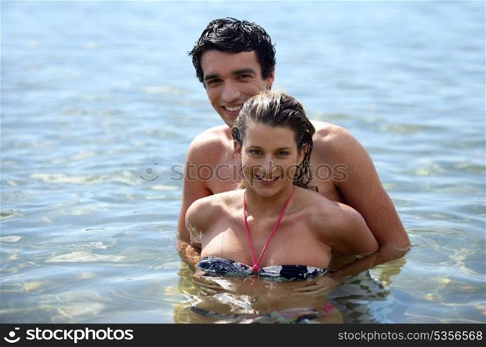 Playful couple frolicking in the sea
