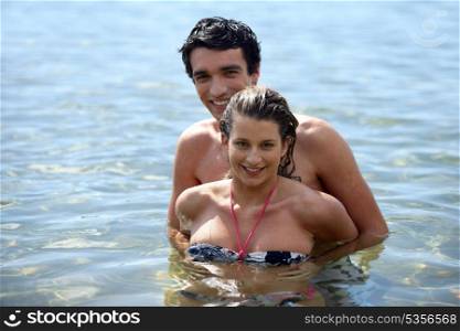 Playful couple frolicking in the sea