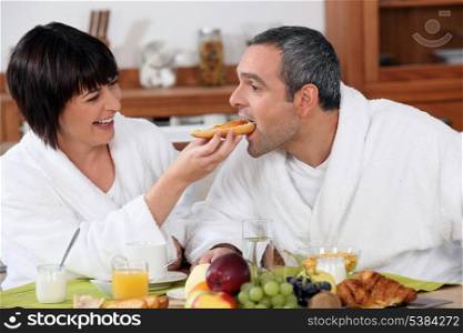 Playful couple having breakfast