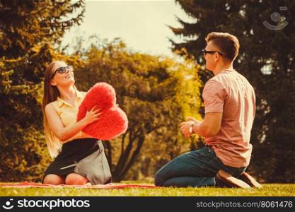 Playful couple in park. . Love romance relationship dating leisure concept. Playful couple in park. Young girl boy spending time tossing heart outdoors.