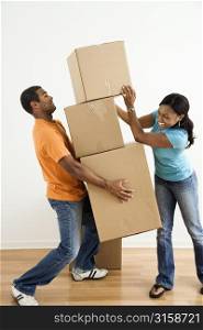 Playful couple moving boxes