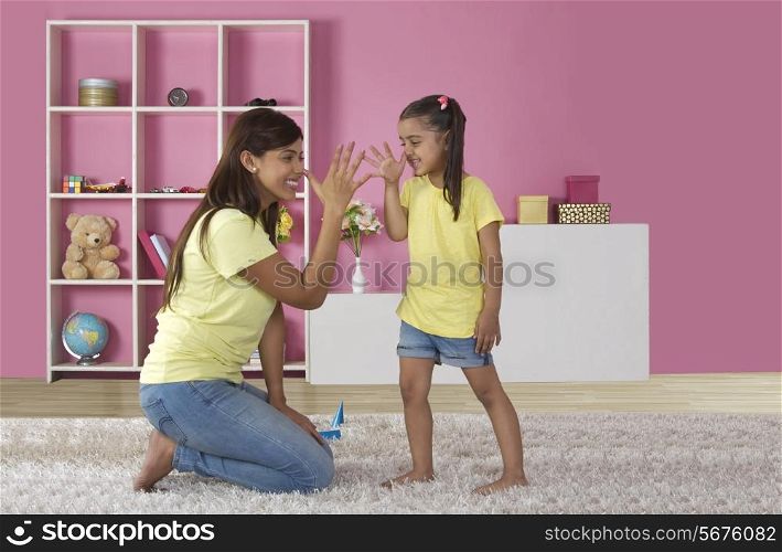 Playful daughter and mother teasing each other at home