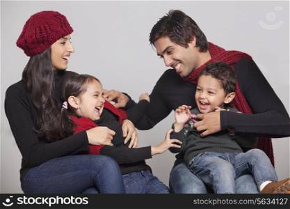 Playful family sitting over grey background